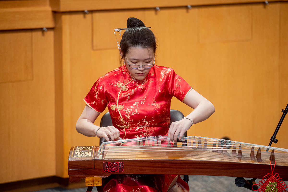 Female musician playing the guzheng at the Asian American and Pacific Islander Celebration